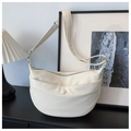 Detail van een crème beige leren hobo-tas met voorvak op een minimalistische tafel - Off-wit