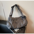 Detail of dark grey pleated nylon tote bag with wide knotted shoulder strap on books - Gray
