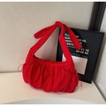 Detail of red nylon tote bag featuring ruffled texture and a large decorative bow - Red