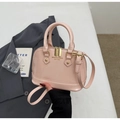 Detailed view of pink patent leather shell bag with gold hardware and dual handles - No Pendant / Pink