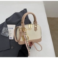 Detail of glossy two-tone shell bag featuring golden hardware and decorative charms - With Pendant / White & Khaki