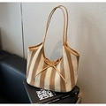 Close-up of woven tote bag with brown stripes, leather straps and bow detail - Vertical Striped Woven (Khaki) / Striped Khaki