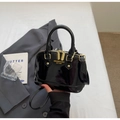 Close-up of black shell-shaped patent leather handbag with gold hardware details - No Pendant / Black