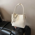 Cream-colored bucket bag in litchi grain leather with dual handles and slim strap - White Without Pendant