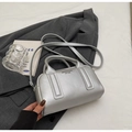 Silver metallic bowling handbag in lychee texture with crossbody strap on a grey blazer - Silver (No Pendant)