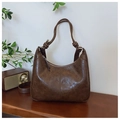 Detalle del bolso de hombro vintage marrón con textura de cuero encerado y correa con nudos - Marrón
