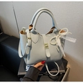 Détail du sac seau bleu clair à motif litchi avec breloque perle et fermoir doré chic - Bleu avec Pendentif