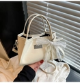 Close-up of cream bow shoulder bag with pearls and silver brand plate detail - Beige With Charm