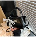 Close-up of black PU leather handbag featuring a pearl bow and lace ribbon charm - Black with Pendant