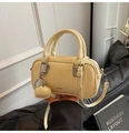Detail of a creamy yellow mini boston bag showing fine texture and a heart charm - With Pendant / Pale Yellow with Pendant