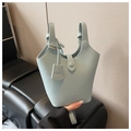 Detailaufnahme der hellblauen Eimer-Tasche aus Leder mit Lychee-Muster und Markenanhänger - Blau