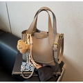 Dettaglio della borsa in pelle taupe grana litchi con timbro moda e ciondolo a orsetto - Grigio Elefante con Ciondolo