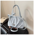Dettaglio borsa azzurra con texture plissettata e fiocco con elemento in metallo argento - Blu