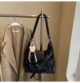 Detalle de bolso tote negro con textura de mármol, colgante de oso blanco y solapa imantada - Negro con colgante