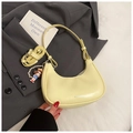 Detail of pale yellow crescent hobo bag with pearl charm on grey blazer backdrop - Yellow with Pendant