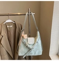 Primer plano del bolso tote verde menta con solapa blanca, textura de nube y dije de oso - Verde con Colgante