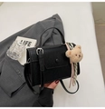 Dettaglio borsa a tracolla in PU nera con ciondolo a orsetto e foulard su abito grigio - Nero con ciondolo