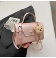 Dettaglio borsa quadrata in pelle martellata rosa con ciondolo a forma di orsetto bianco - Rosa con ciondolo