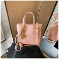 Detail der rosa Modetasche mit goldenen Anhängern und verstellbarem Schultergurt - Rosa
