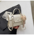 Dettaglio borsa a tracolla crema con ciondolo a forma di orsetto e coulisse a righe - Beige Con Ciondolo