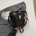 Elegante borsa a secchiello trapuntata nera con dettagli dorati e ciondolo intrecciato - Con Ornamento / Nero