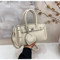 Detail of beige lychee pattern leather handbag with silver lock and heart charm - Pearl White With Pendant