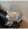 Detailansicht der silbernen Handtasche mit Webstruktur, Riemen und Plüsch-Anhänger - Mit Anhänger / Silber