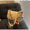 Detail of beige faux leather handbag with silver chain and cute balloon dog charm decoration - With Pendant / Off White