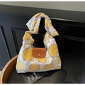 Detail van canvas tas met zonnebloemprint, lederen flap en een ronde gouden gesp - Gele Zonnebloem Stijl