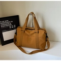 Detail of a large mustard yellow tote bag with dual handles and adjustable shoulder strap - Brown