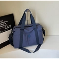 Detail view of large blue travel tote featuring nylon fabric and adjustable strap - Blue