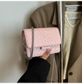 Mini borsa rosa intrecciata a tracolla con catena d'argento su un blazer marrone - Rosa