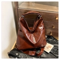 Detailed view of the large brown hobo bag showing retro oiled leather texture and side pocket - Cherry Red