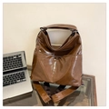 Close-up of vintage brown leather tote bag with dual front pockets and glossy texture - Brown