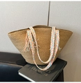 Detail der handgewebten Stroh-Tasche mit bunten geflochtenen Griffen und Naturquasten - Braun