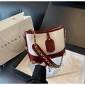 Détails du sac seau rétro avec coins métalliques dorés et finitions en cuir rouge - Bordeaux