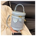 Detail der hellblauen Zylindertasche mit gewebter Textur und goldfarbenem Reißverschluss - Blau