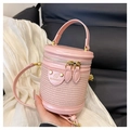 Details der rosa gewebten Zylindertasche mit Lederpatch und goldenen Reißverschlüssen - Rosa