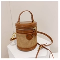 Detail einer braunen Leder- und Stroh-Zylindertasche mit Metallreißverschluss und Markenlogo - Braun