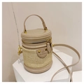 Nahaufnahme der beige Stroh-Eimertasche mit Lederbesatz und goldenen Metallelementen - Khaki