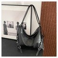 Detailed view of black faux leather tote with silver metal rings and adjustable side straps - Black