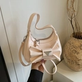 Fashionable creamy pink crossbody bag featuring a large bow and metallic triangle detail - Pink