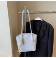Dettaglio borsa a secchiello azzurra in pelle con ciondolo intrecciato e oro - Con Ciondolo / Azzurro