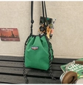 Detail of green plaid drawstring bucket bag showing urban lifestyle aesthetic and logo - Green