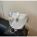 Detail of light blue bucket bag with silver clasp, pearl chain, and plaid bow charm - With Charm / Blue