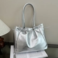 Zilveren metallic tote bag met strikdetail en lange hengsels in een moderne setting - Zilver