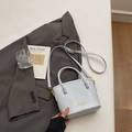 Elegant ice blue bucket bag with gold branding, featuring double handles and crossbody strap - Light Blue Without Pendant