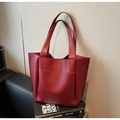 Detalle de bolso tote grande rojo oscuro con textura de cuero mate y bolsillo frontal - Burdeos