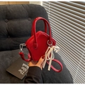 Close-up of star-shaped red patent leather bag with elegant pearl bow charm - With Charm / Burgundy