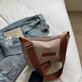 Beige Nylon Umhängetasche mit braunem breitem Schultergurt auf weißer Bettwäsche - Khaki